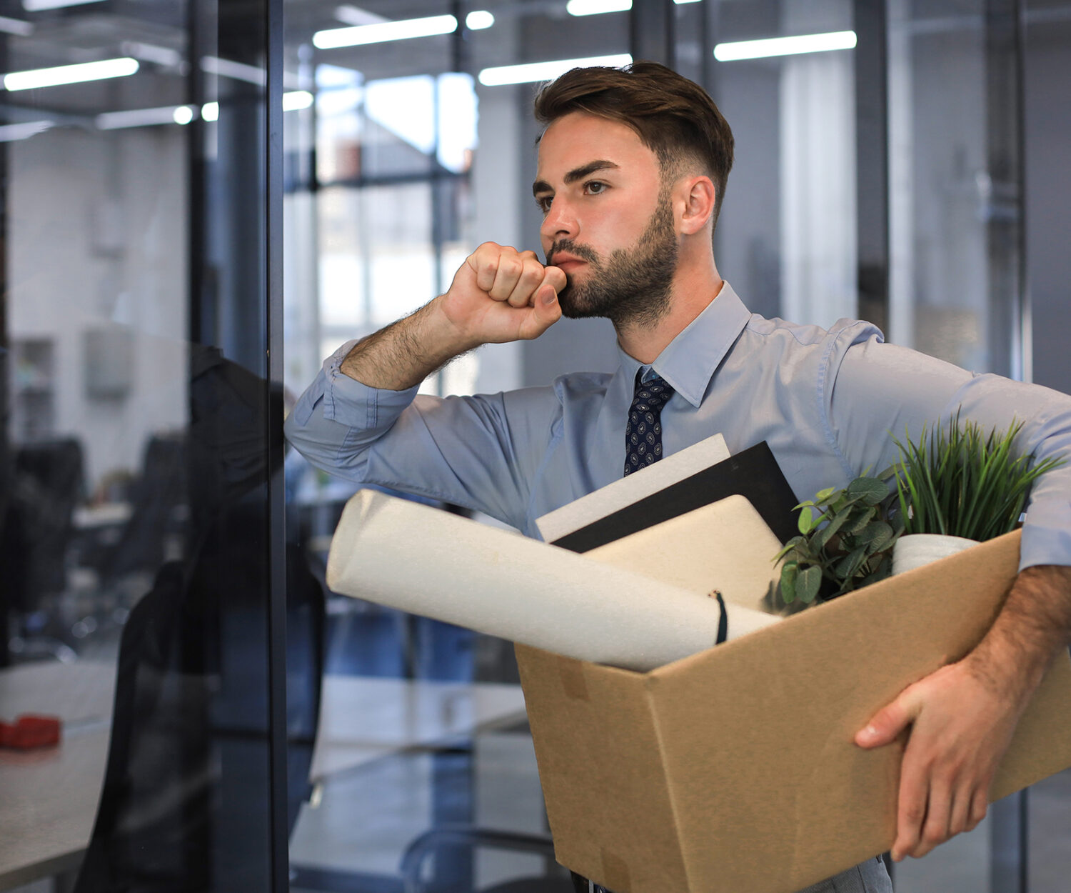 Sad dismissed worker is taking his office supplies with him from office