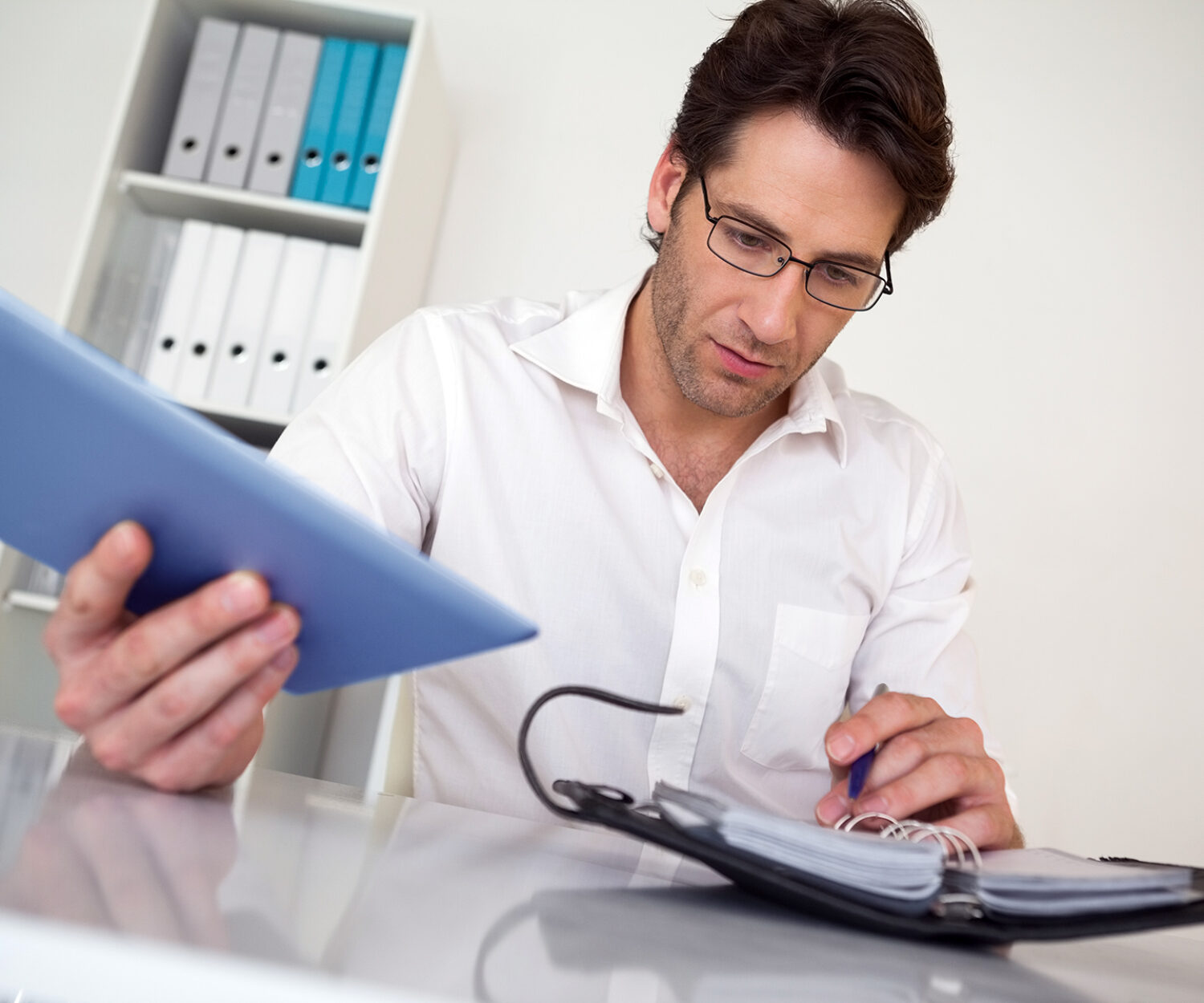 Casual businessman organizing his schedule at his desk in his office